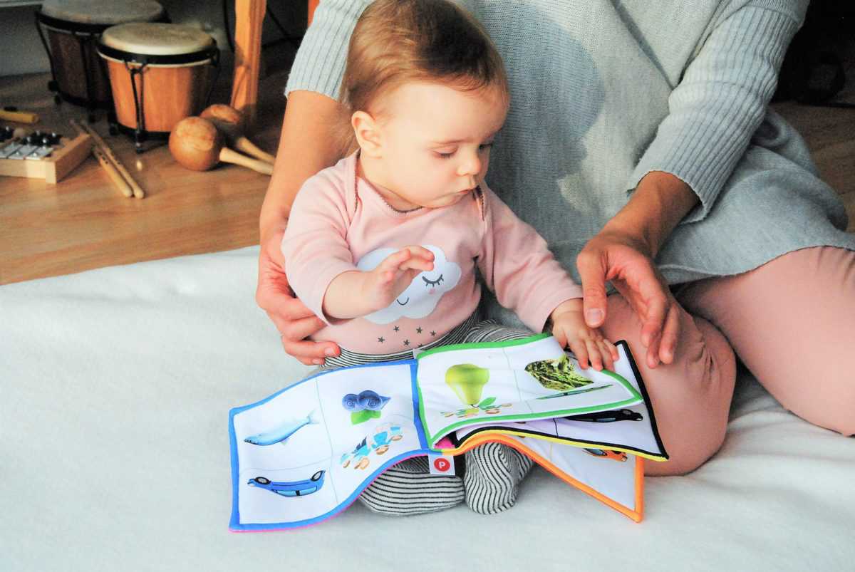 Baby with parent reading picture book
